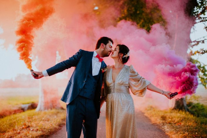 photo d'un couple de mariés avec fumigènes colorés